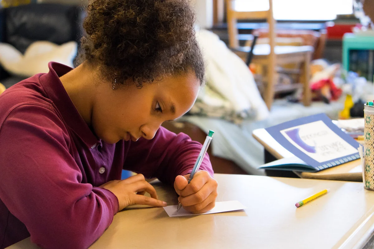 The Imago School Maynard MA Classical Christian Education MetroWest Boston Girl working at desk at the classical Christian School The Imago School in Maynard MA for Prek through 12th grade